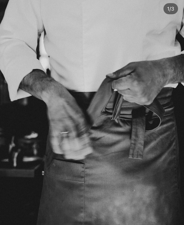 camarero atándose el delantal en blanco y negro